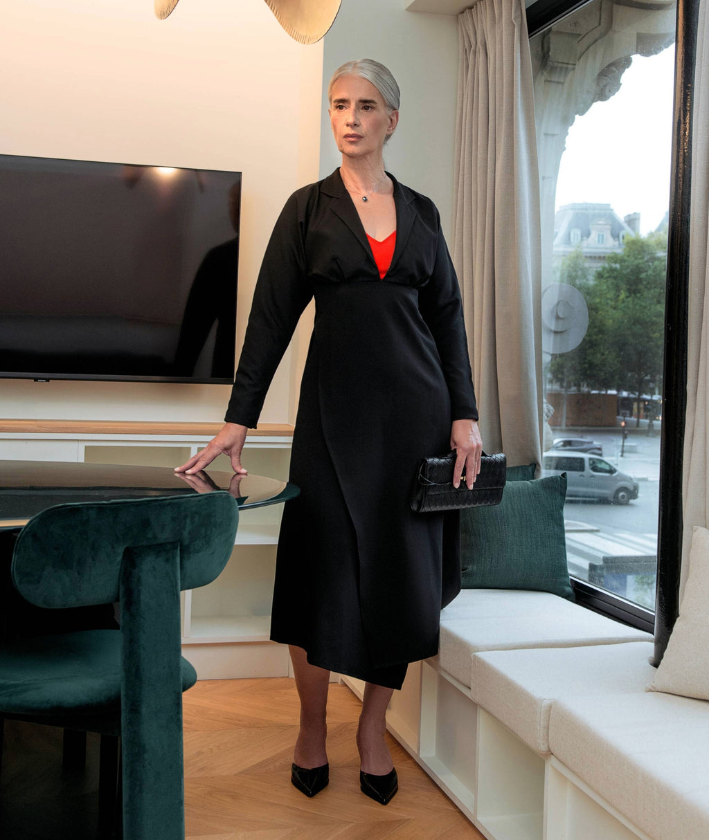 Side view of Drift Midi Dress black midi dress by IKKHO showing overlapping panels and fluid silhouette