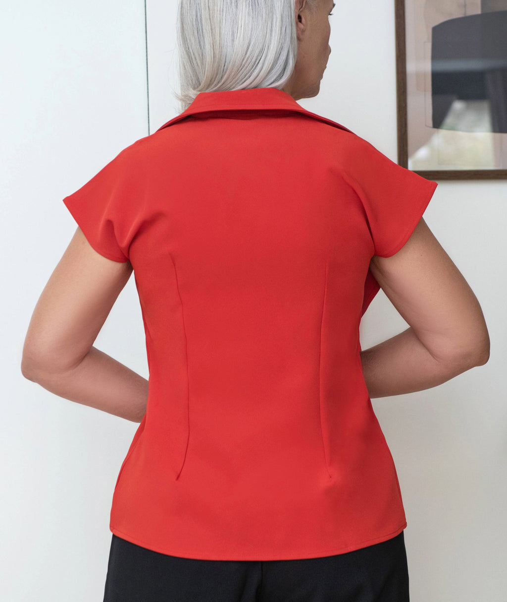 Back view of Wave Overlap modern tunic in orange showing fluid sleeves